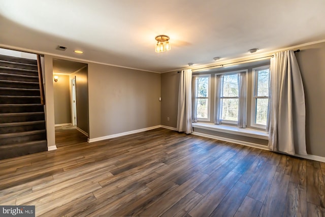 interior space with visible vents, baseboards, stairway, ornamental molding, and dark wood-style flooring