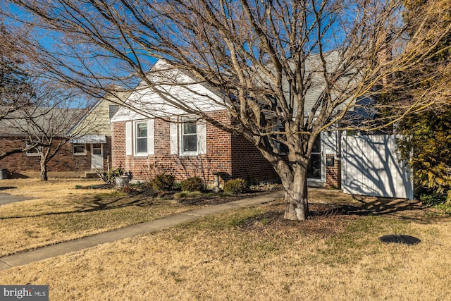 view of front facade with brick siding and a front yard