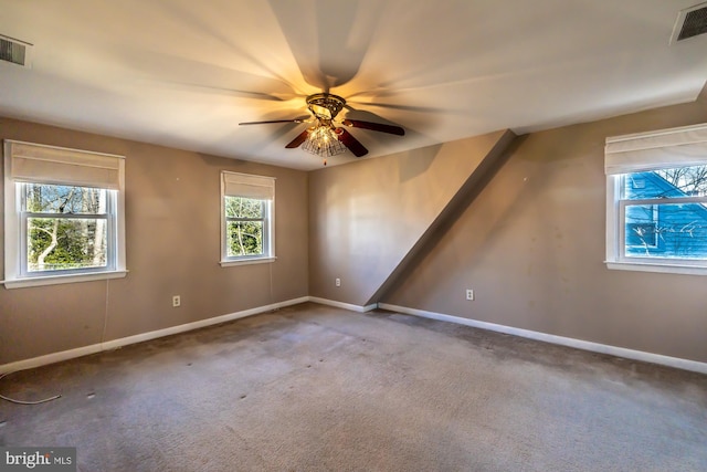 carpeted spare room with visible vents, ceiling fan, and baseboards