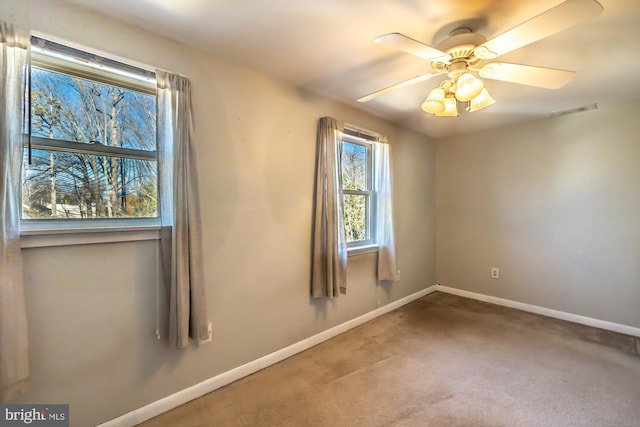 spare room with visible vents, ceiling fan, baseboards, and carpet floors