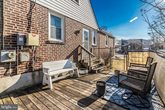 wooden terrace featuring a residential view, entry steps, and a gate