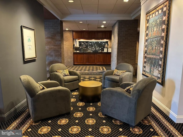 carpeted home theater with a drop ceiling, recessed lighting, brick wall, and baseboards