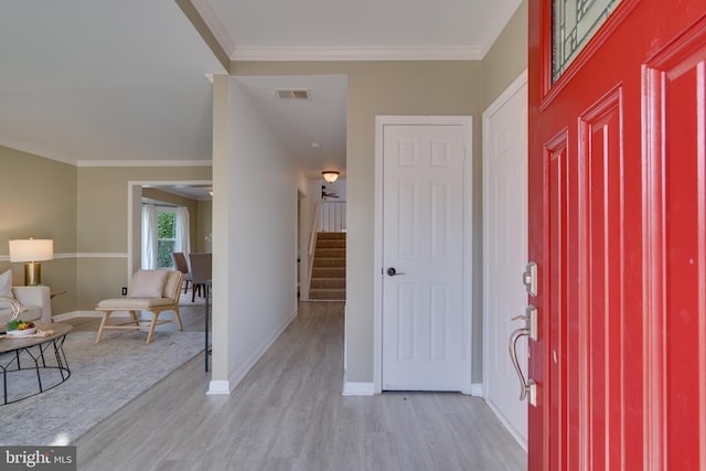 entrance foyer with light wood finished floors, visible vents, crown molding, baseboards, and stairs