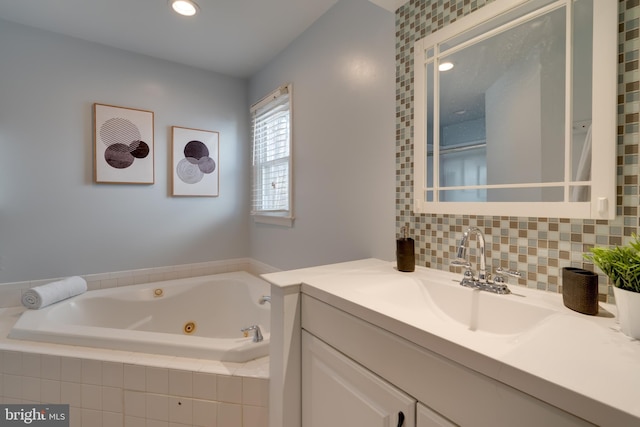 bathroom with vanity, recessed lighting, a whirlpool tub, and backsplash