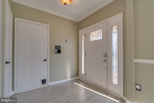 entrance foyer featuring baseboards, light wood-style floors, and ornamental molding