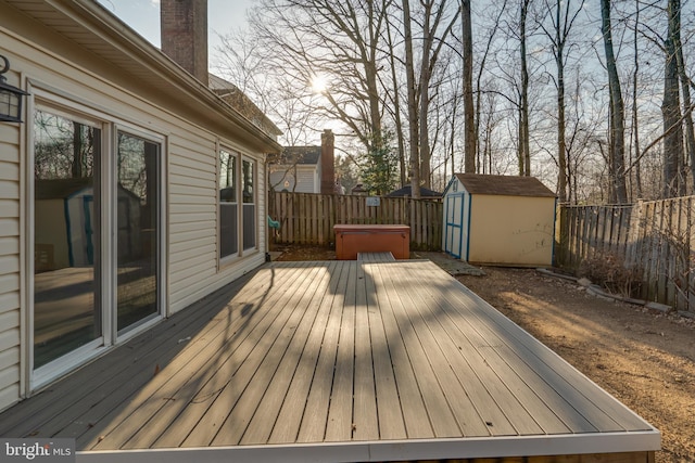 deck with a storage unit, a fenced backyard, and an outdoor structure