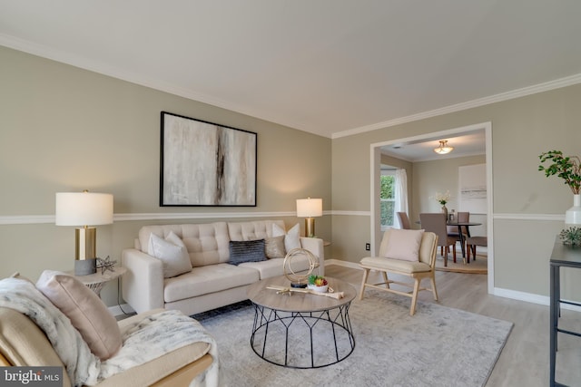 living area with wood finished floors, baseboards, and ornamental molding