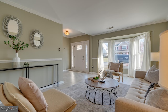 living room with visible vents, ornamental molding, baseboards, and wood finished floors