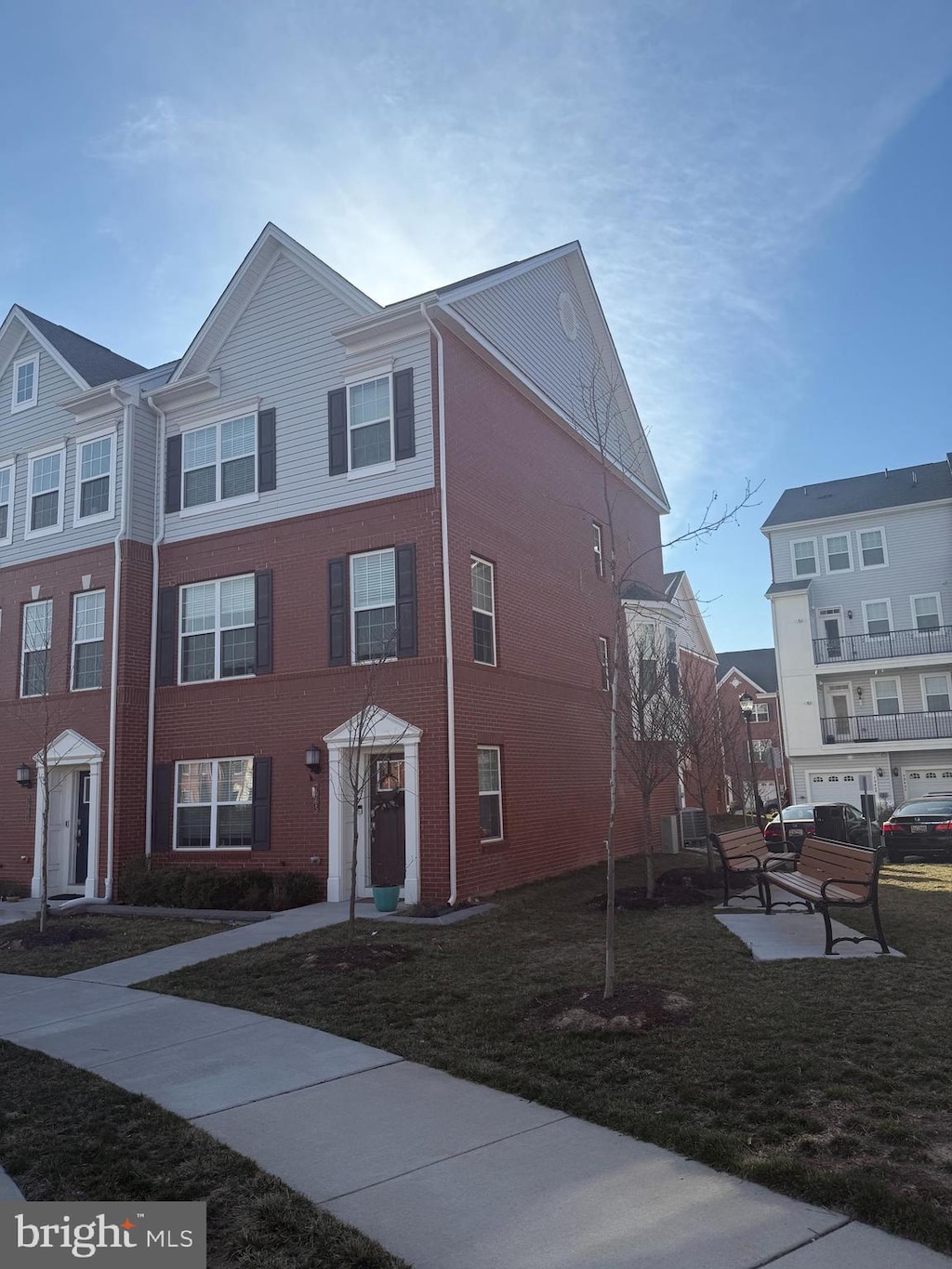 multi unit property featuring brick siding and a front yard