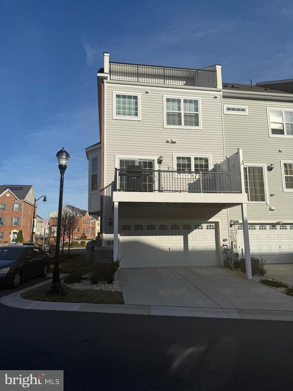 multi unit property featuring a garage and concrete driveway