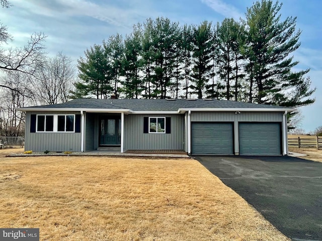 ranch-style house with a front lawn, fence, aphalt driveway, a chimney, and an attached garage