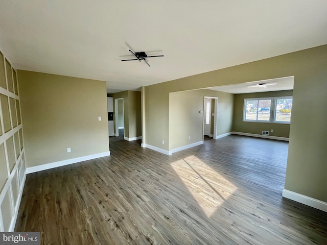 unfurnished living room with wood finished floors, a ceiling fan, and baseboards