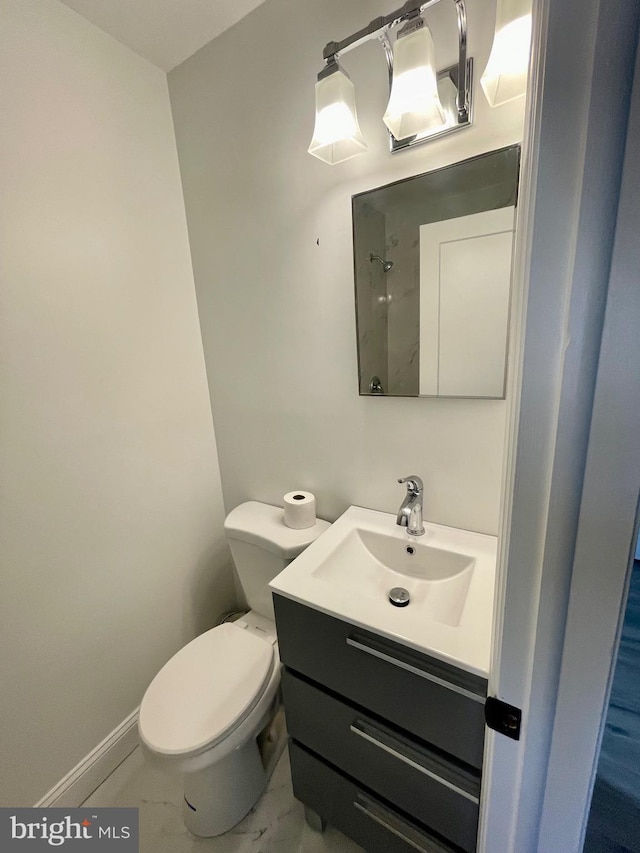 bathroom with vanity, toilet, and baseboards