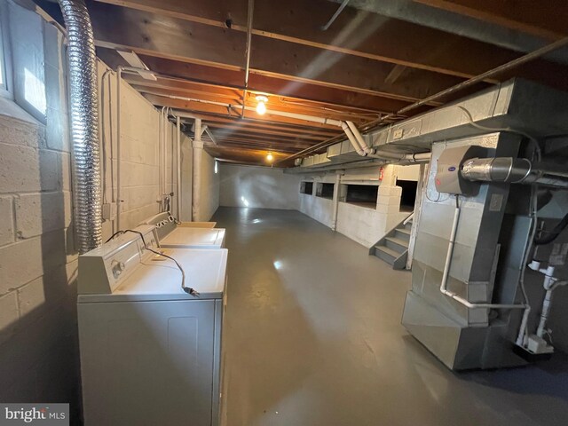 unfinished basement featuring washer and dryer and heating unit