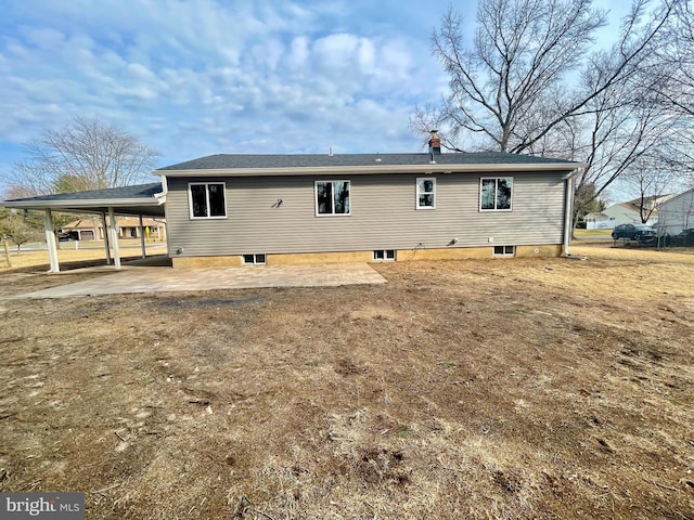 rear view of house featuring an attached carport, driveway, and a patio