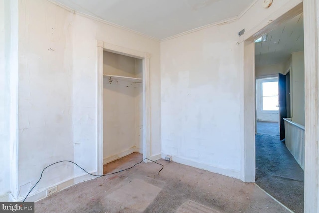 unfurnished bedroom featuring a closet, concrete floors, and crown molding