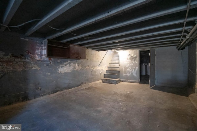 unfinished basement featuring stairway