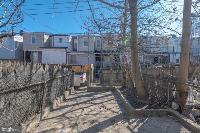 rear view of house featuring a residential view and fence