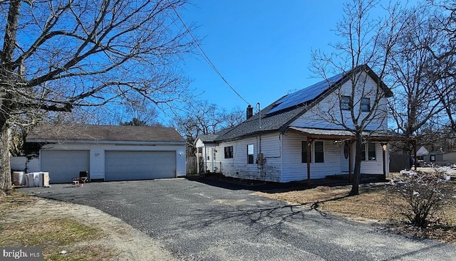 123 S 9th St, Millville, NJ 08332 - view of side of home with an outbuilding, driveway, a garage, solar panels, and a chimney