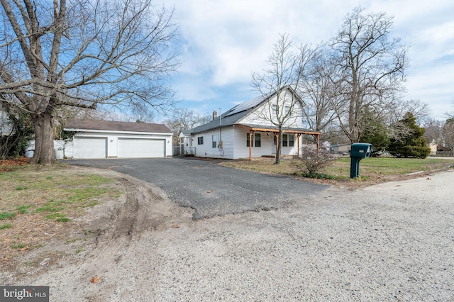 123 S 9th St, Millville, NJ 08332 - view of front of house with aphalt driveway, a garage, solar panels, and an outdoor structure