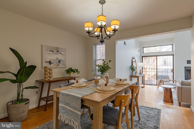 dining space with visible vents, a notable chandelier, baseboards, and light wood-type flooring