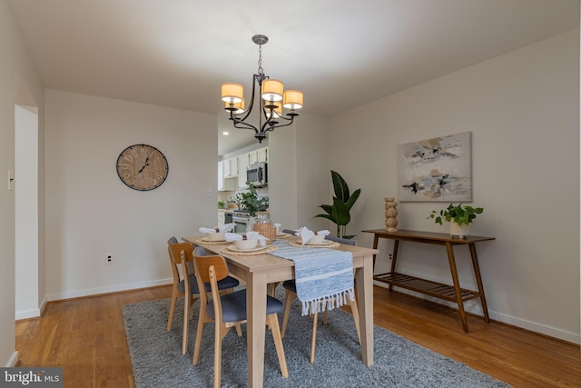 dining space featuring recessed lighting, baseboards, light wood finished floors, and a chandelier