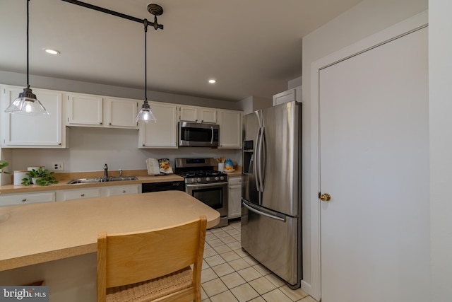 kitchen with light tile patterned floors, a sink, stainless steel appliances, light countertops, and white cabinets