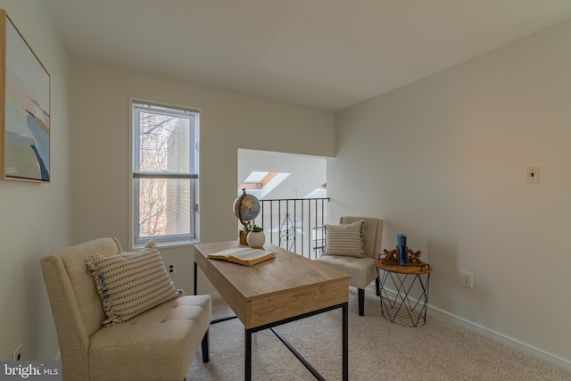 office space featuring baseboards, a skylight, and carpet flooring