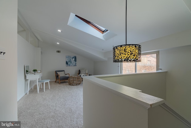 hallway with visible vents, carpet floors, an upstairs landing, recessed lighting, and vaulted ceiling with skylight