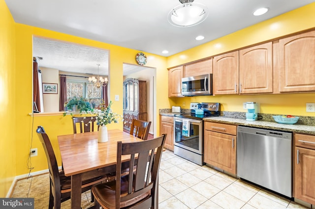 kitchen featuring a notable chandelier, recessed lighting, appliances with stainless steel finishes, light tile patterned floors, and baseboards