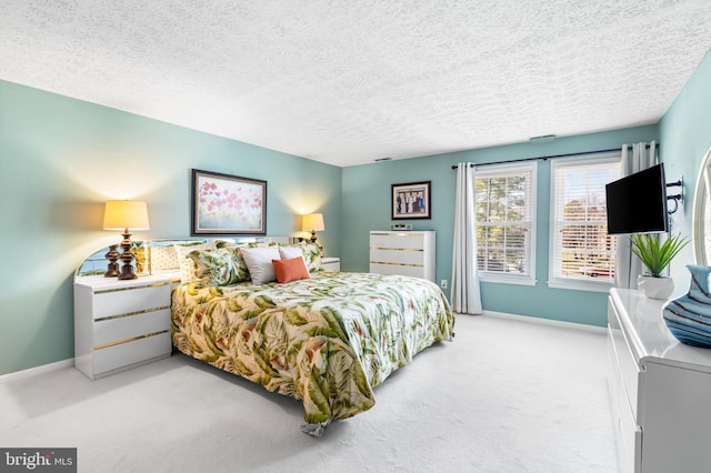 bedroom with a textured ceiling, baseboards, and light carpet