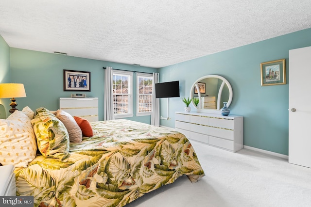 carpeted bedroom featuring baseboards, visible vents, and a textured ceiling