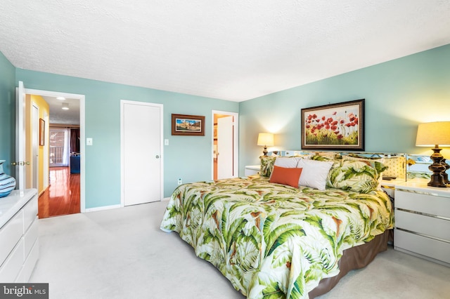 bedroom with light carpet and a textured ceiling