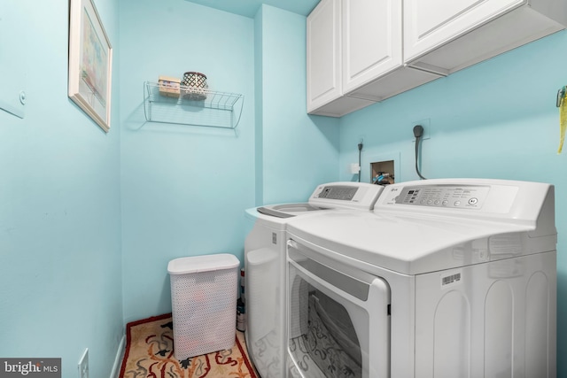 clothes washing area with baseboards, cabinet space, and washing machine and dryer