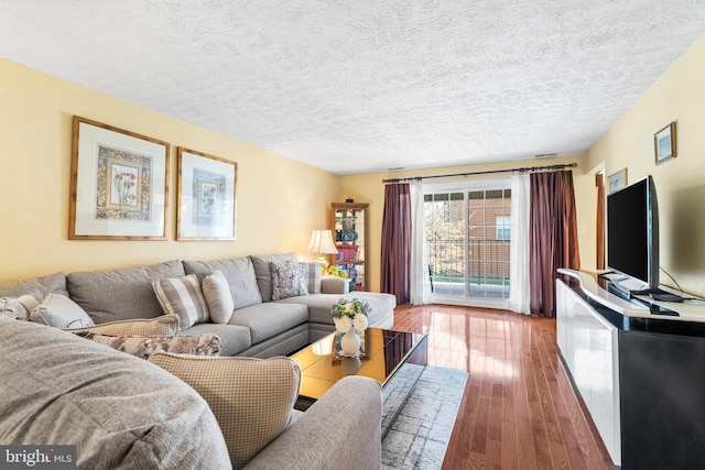 living room featuring a textured ceiling and hardwood / wood-style floors