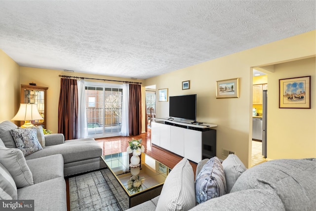 living room featuring tile patterned floors, visible vents, and a textured ceiling