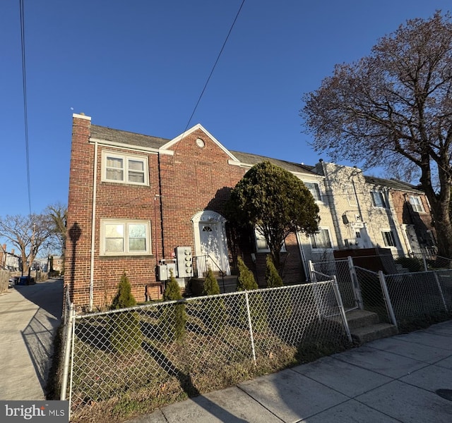 multi unit property with brick siding and a fenced front yard