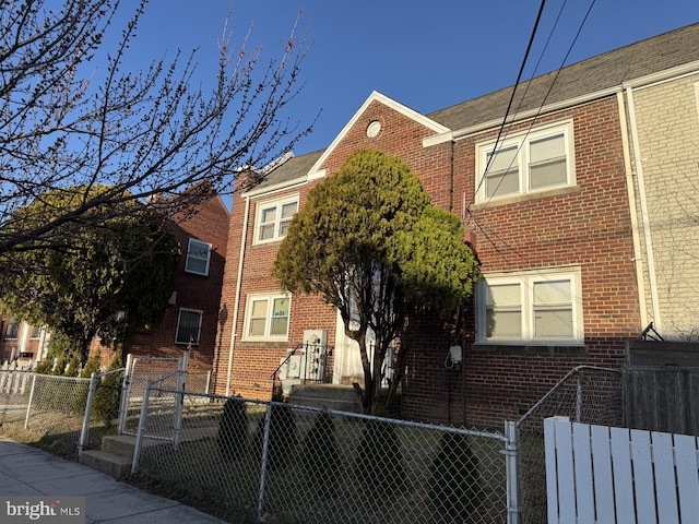 view of front of home with a fenced front yard and brick siding