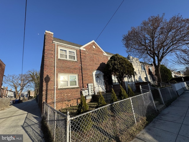 view of front of home featuring brick siding and a fenced front yard