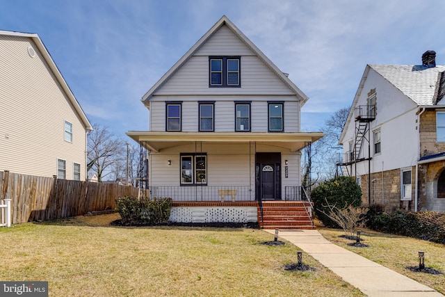 view of front of home featuring a porch, fence, and a front lawn