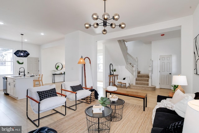 living area with stairs, light wood-style flooring, and a wealth of natural light