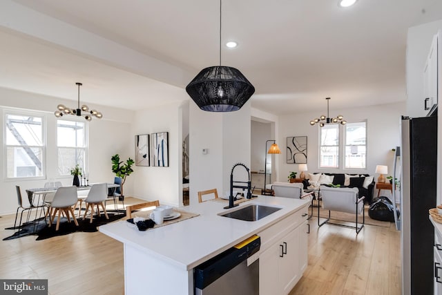 kitchen featuring a chandelier, appliances with stainless steel finishes, light countertops, and a sink