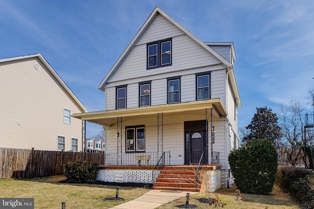 view of front of house featuring a porch, a front yard, and fence