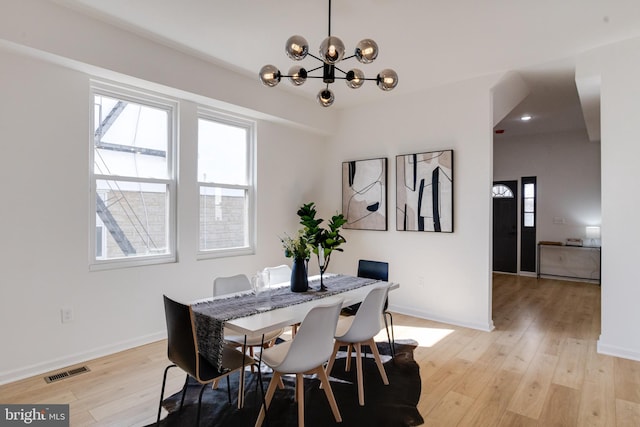 dining room featuring an inviting chandelier, light wood-style floors, and baseboards