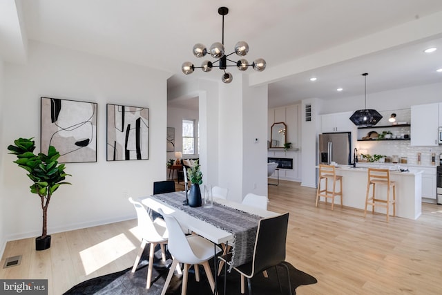 dining space with recessed lighting, visible vents, light wood-style floors, and an inviting chandelier