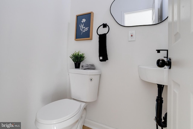 bathroom with toilet and baseboards