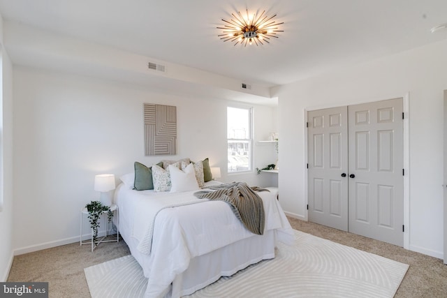 carpeted bedroom with baseboards, visible vents, and a closet