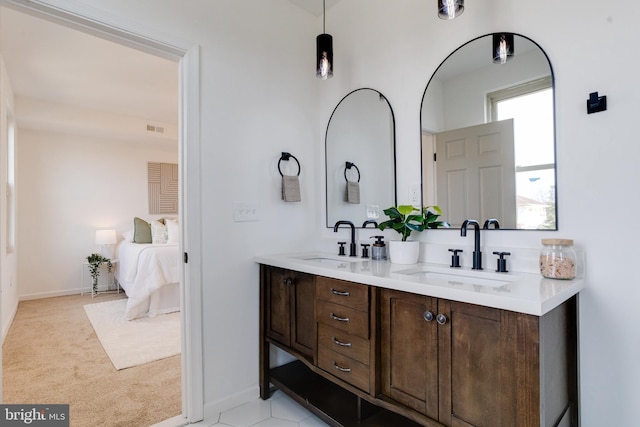 full bathroom with double vanity, visible vents, connected bathroom, and a sink