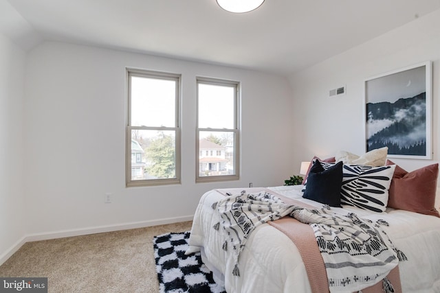 carpeted bedroom with visible vents, baseboards, and lofted ceiling