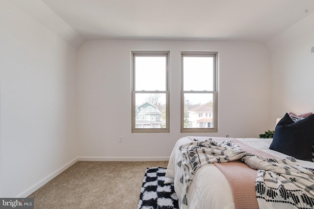 bedroom featuring vaulted ceiling, baseboards, and carpet floors